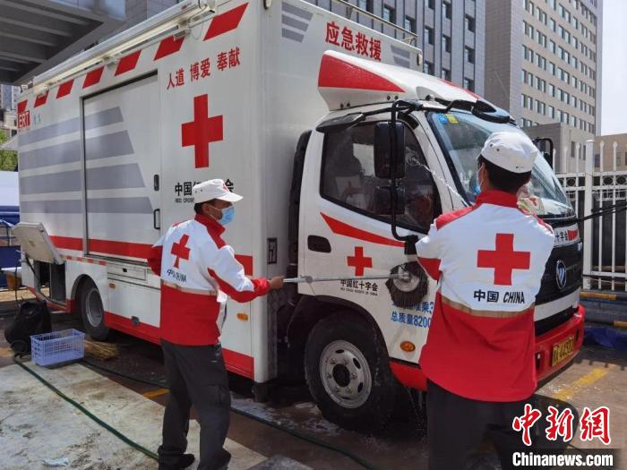 图为志愿者为送餐车辆进行消毒。 青海省红十字会 供图 图为志愿者为送餐车辆进行消毒。 青海省红十字会 供图