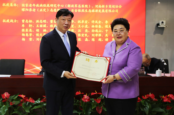 5、事业发展中心向6名养老专家颁发顾问聘书。图为中国蓝田总公司党委书记汤喆（左一）接过聘书。.jpg