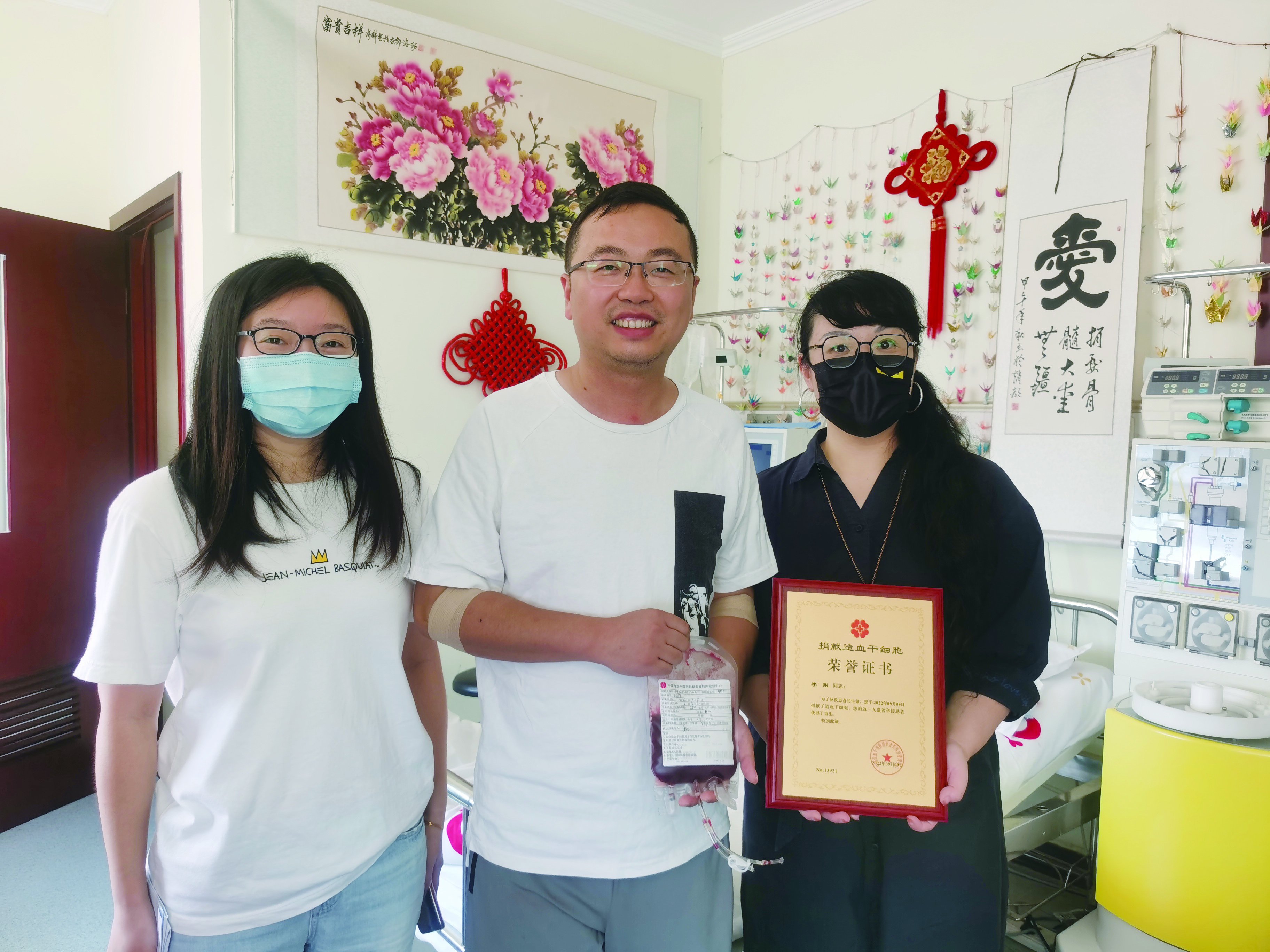 01中华骨髓库国家级管理中心医疗服务部部长杜丹（右）为小李（中）颁发荣誉证书.jpg