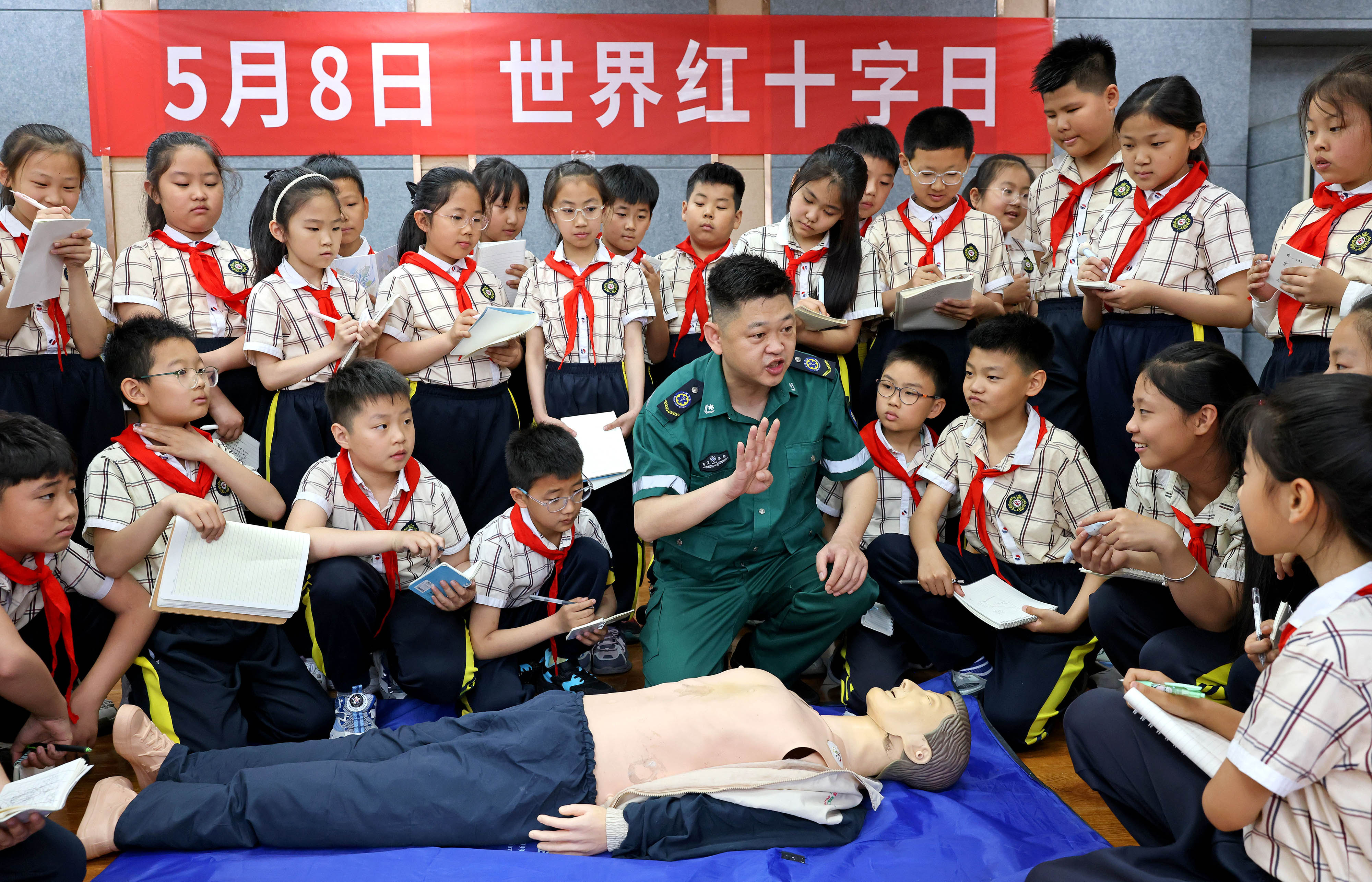 （图1）5月7日，在山东省枣庄市市中区文化路小学，医务人员向学生们讲解心肺复苏急救知识。.JPG
